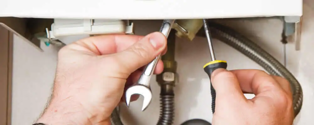 Boiler repair technician tightening pipe fittings and connections in Hoboken, NJ