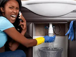 Emergency plumbing repair for a leaking sink drain under a bathroom vanity in Hoboken, NJ