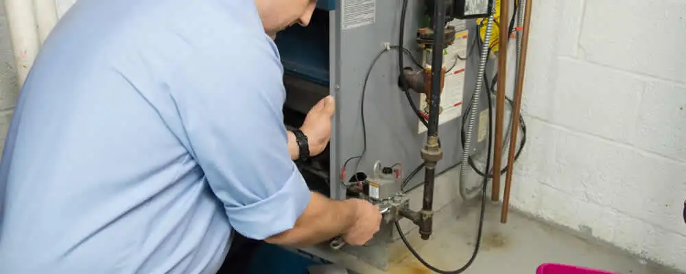 Furnace repair technician inspecting and servicing a home heating system in Hoboken, NJ