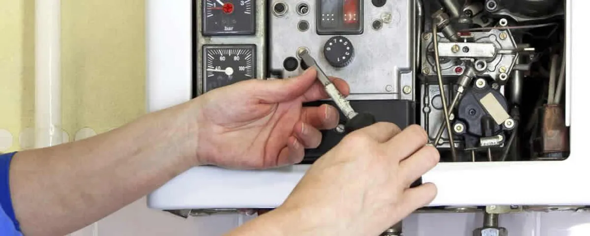 Heating repair technician adjusting boiler controls and components in Hoboken, NJ